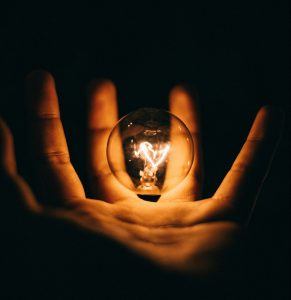 Hand holding lit bulb