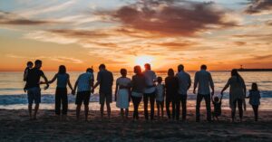 People holding hands on a beach during sunset