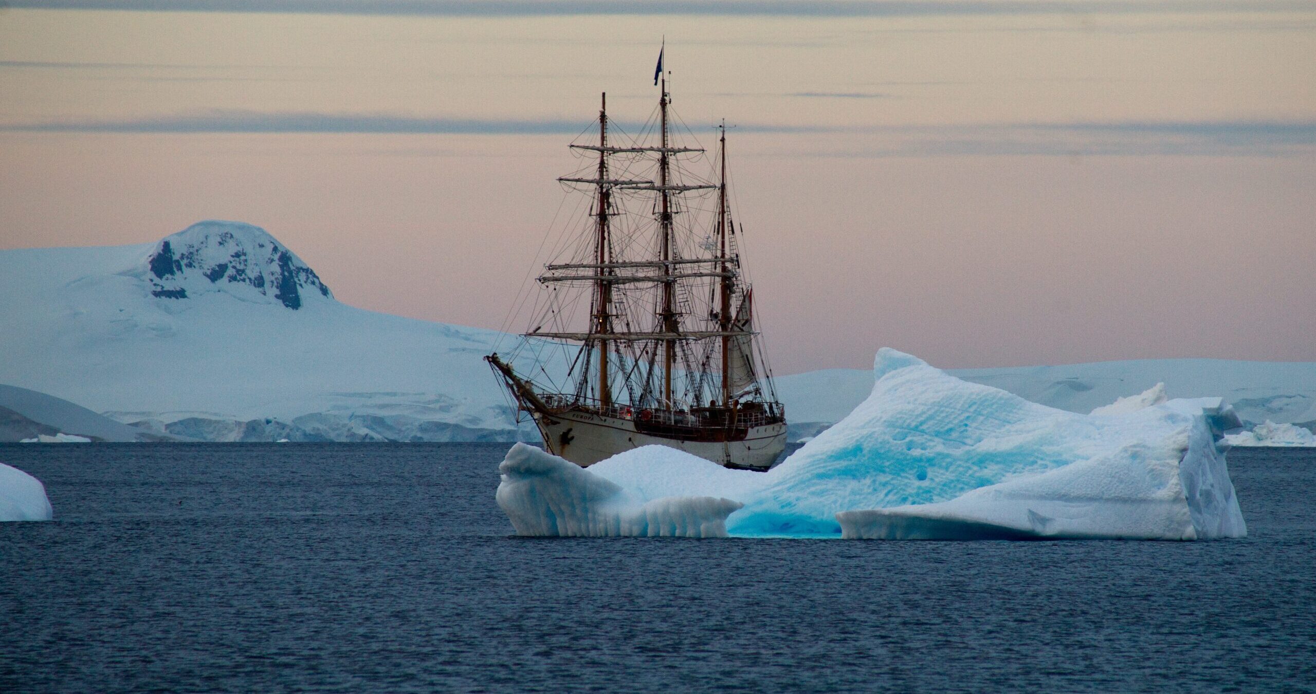 ship sailing past icebergs