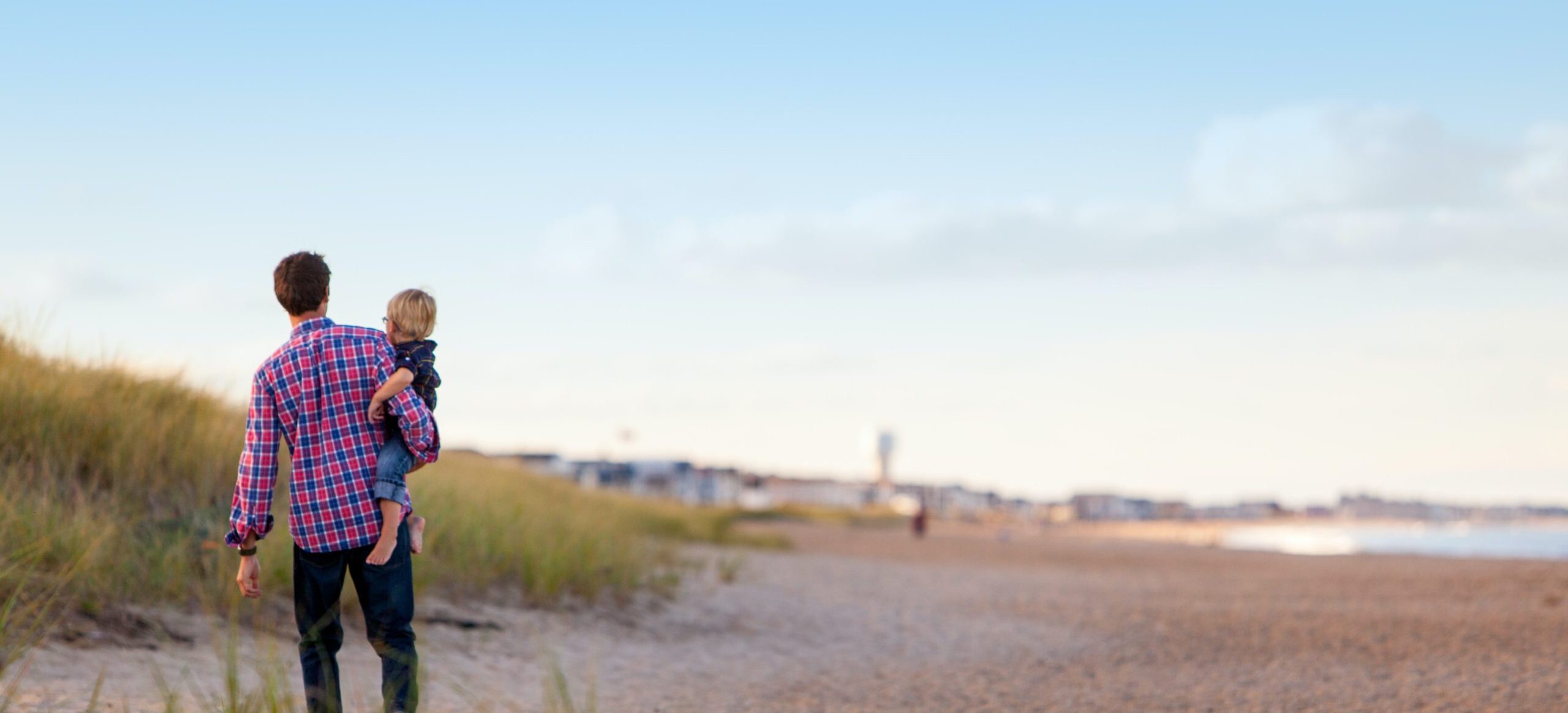 Father holding son on beach
