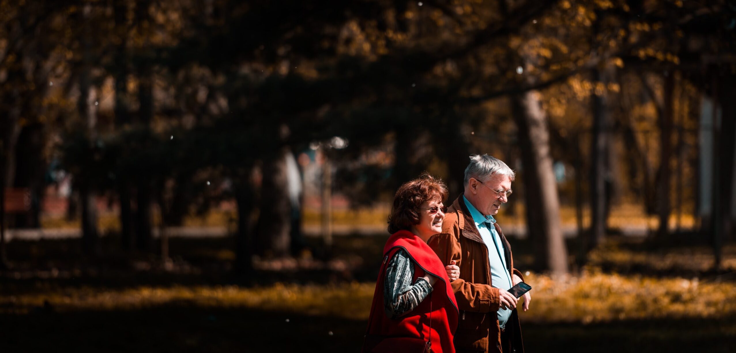Old couple walking through a forest