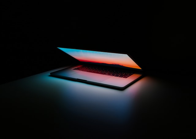 Opened laptop lit-up on dark background